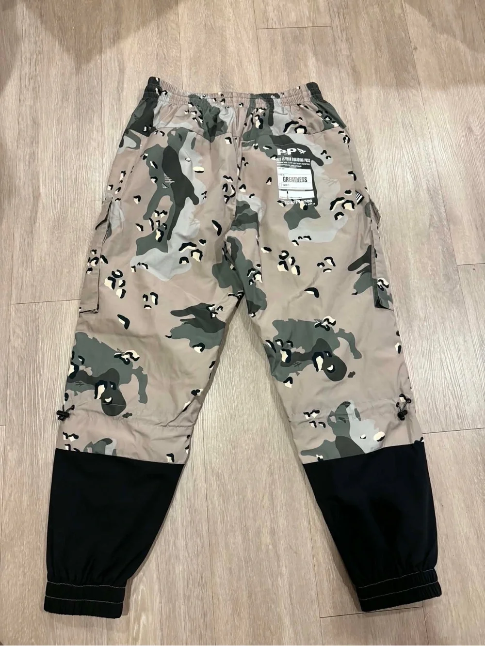Paper Planes multi-pocket cargo pants featuring an all-over camouflage print